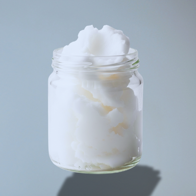 Glass jar filled with Coconut oil against a gray background