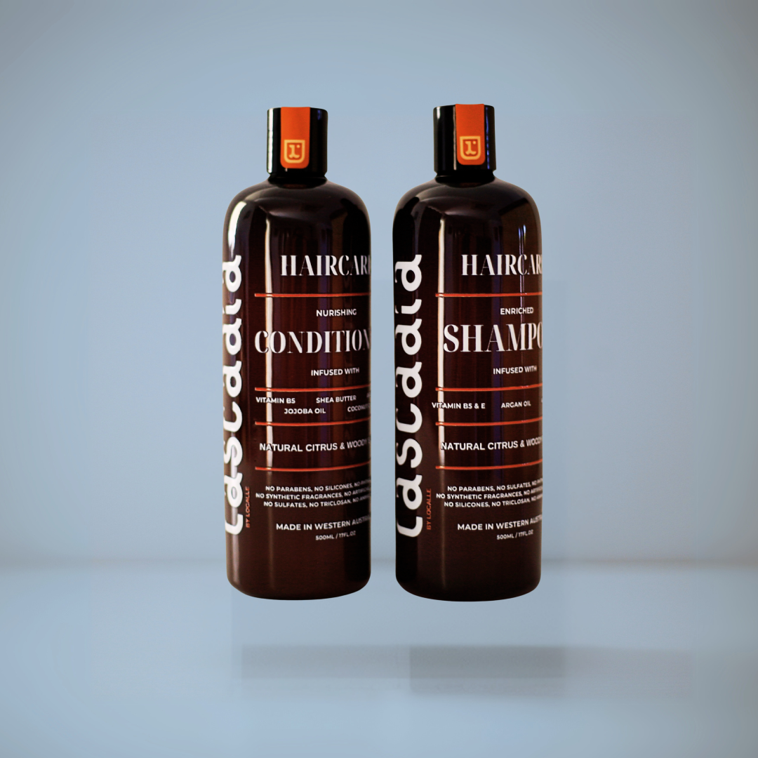 Two bottles of ascada hair care products on a light gray background