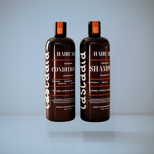 Two bottles of ascada hair care products on a light gray background